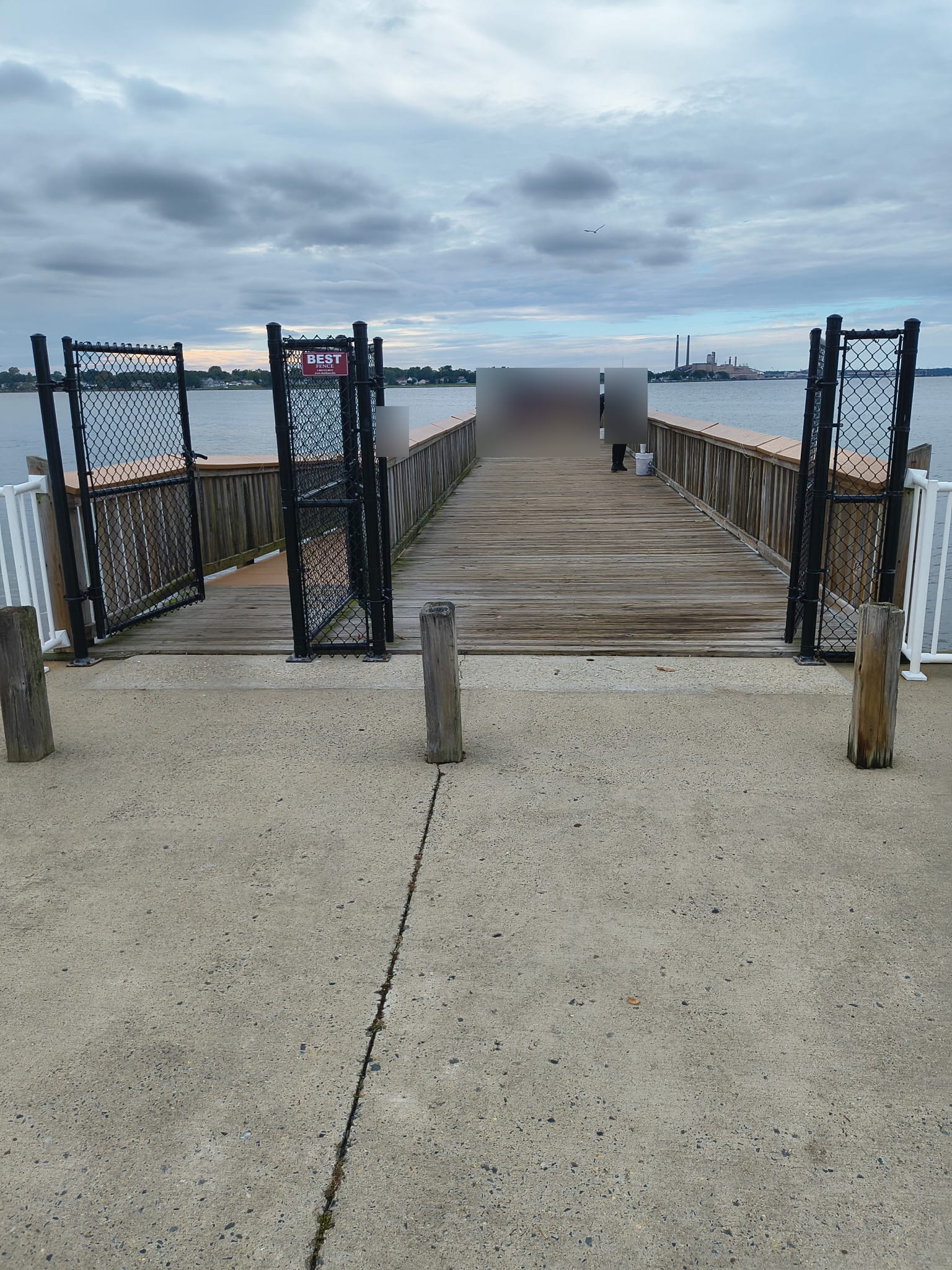 Fort Smallwood Park Fishing Pier · The timber fishing pier and side railings at Fort Smallwood Park. Trusted-agent photo reviewed October 3, 2026; visit date unconfirmed. Visitors have been obscured for privacy. · FindAPier trusted field agent