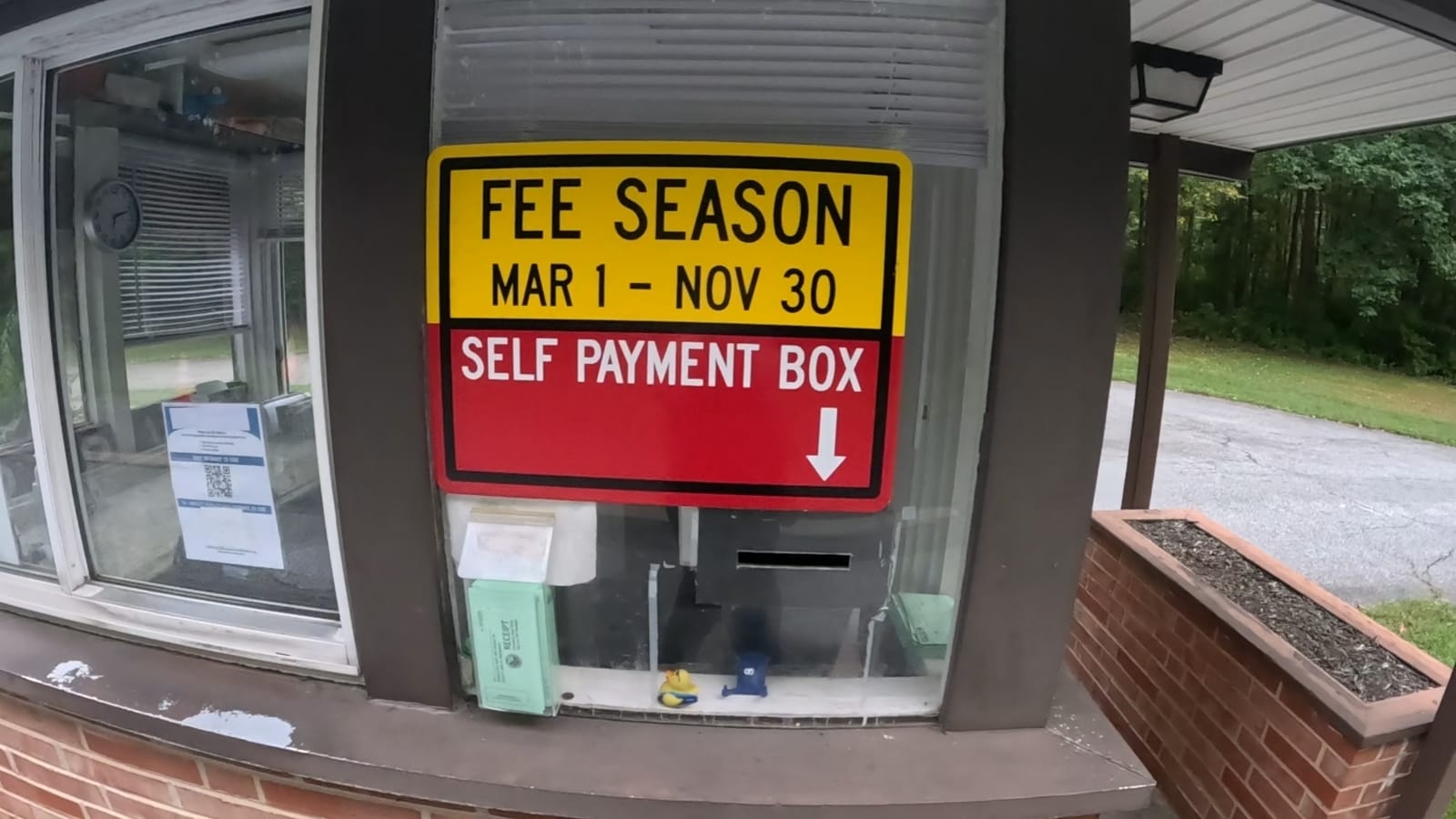The entrance booth posts the March 1 through November 30 fee season and points to the self-payment box.