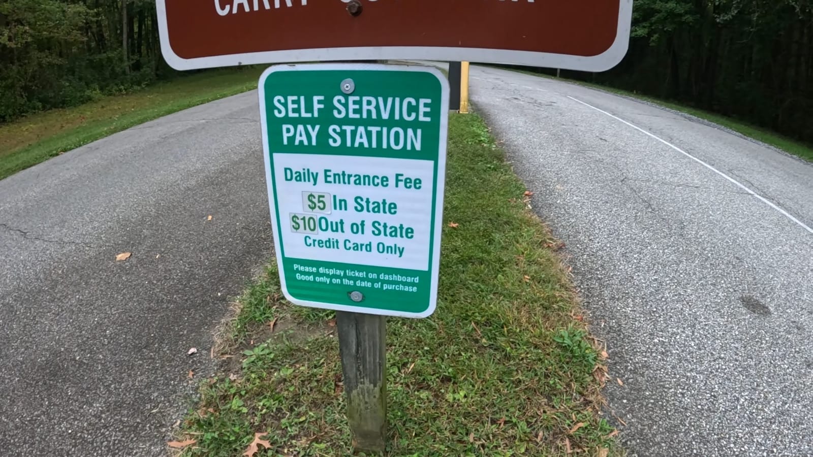 The self-service entrance-payment sign specifies credit card only and instructs visitors to display the ticket on the dashboard.